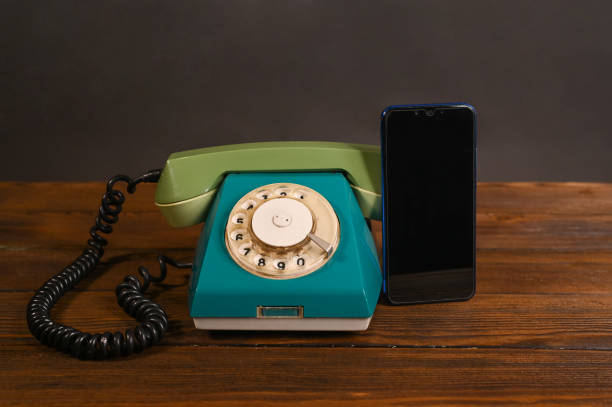 an old wired phone and a modern smartphone