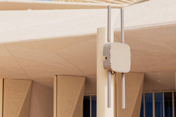 Outdoor wireless access point mounted on a pole, providing high speed Wi Fi connectivity to a modern building